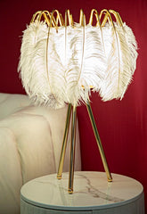 Lámpara de mesa de metal dorado con pantalla de plumas blancas