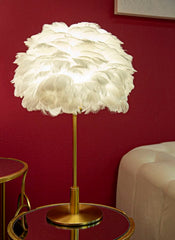 Lámpara de mesa de metal dorado con pantalla de plumas blancas