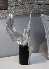 Estatuilla plateada con alas extendidas